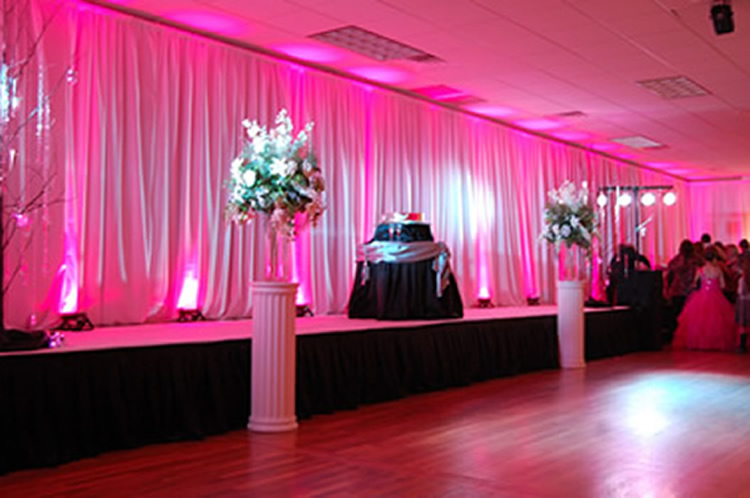 Pink Uplighting on Pipe & Drape Backdrop | Rent online for $19/each + free shipping both ways nationwide at www.RentMyWedding.com/Rent-Uplighting