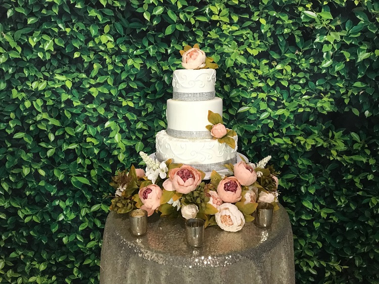 boxwood backdrop with wedding cake